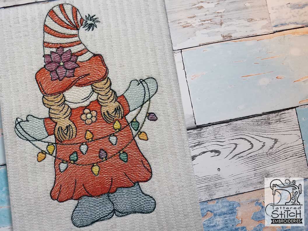 Girl gnome holding string of Christmas lights embroidery design